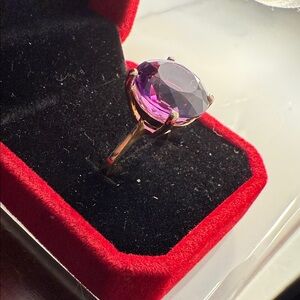 Deeply saturated, purple amethyst set in a 14 karat gold solitaire setting.